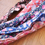 Retro rose print ties displayed on wooden table.