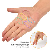 Close up of person holding scissors, extra strong mini rubber bands for versatile hair styling.