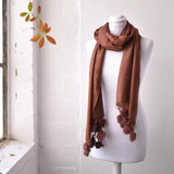 Faux Fur Pom Pom Pashmina Winter Scarf next to window with mannequin