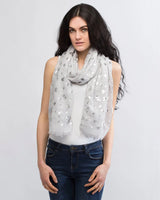 Woman wearing white scarf with grey and white flowers
