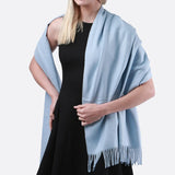 Woman wearing a blue and black dress and cashmere feel oversized scarf