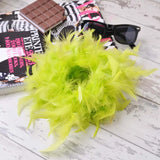 Green feather hair scrunchie accessory on white table