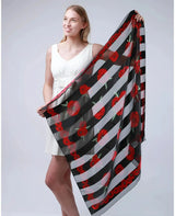 Woman wearing a black and white striped scarf with red flowers, Poppy Square Scarf & Holder Set for Remembrance Day.