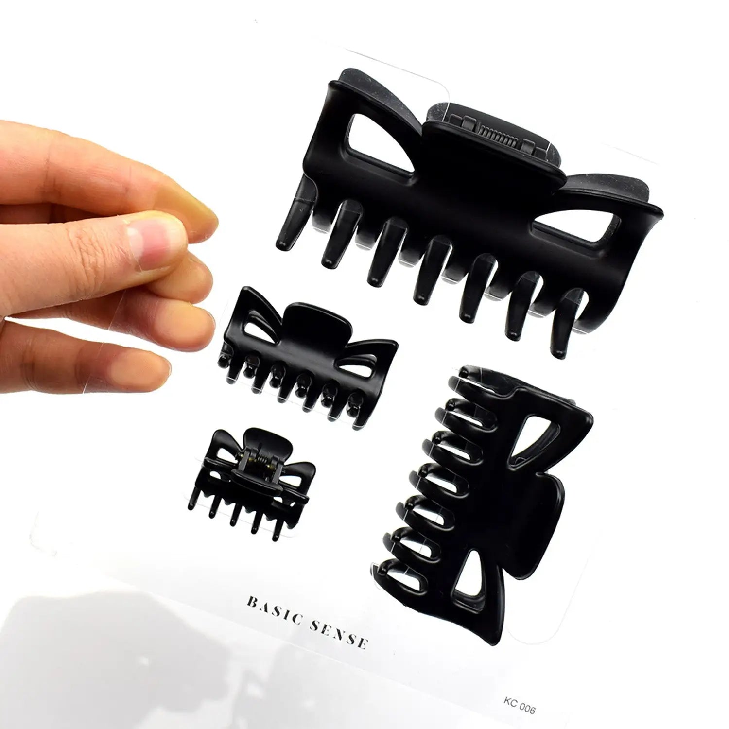 Essential Hair Claw Clips Set, Multi Size - 4pcs - Black plastic claw clip held in hand