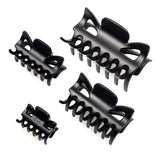 Essential Hair Claw Clips Set - Four black clips on white surface.