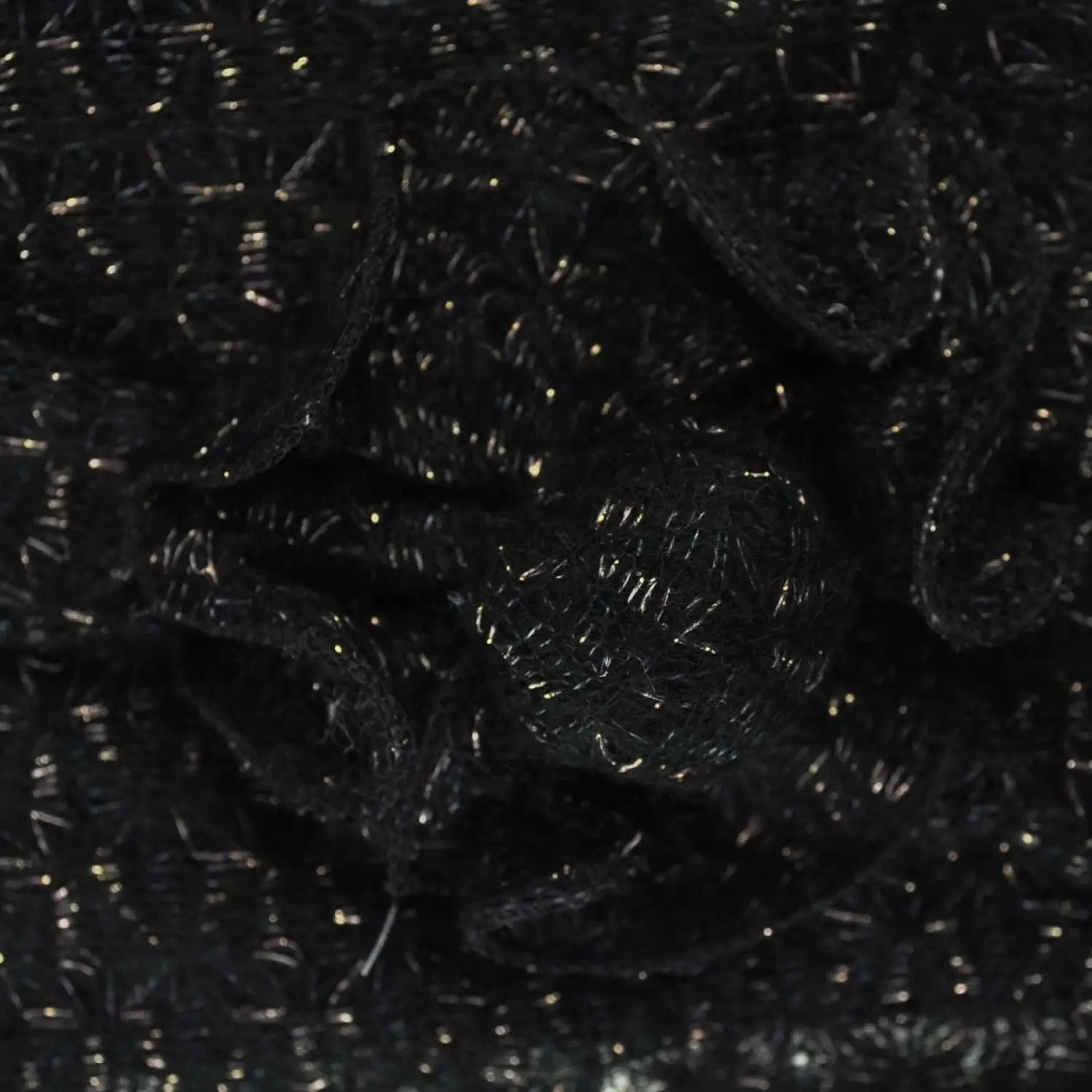 Shimmering knitted flower scarf with pile of black plastic waste