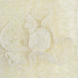 Shimmering knitted flower painting on white surface.