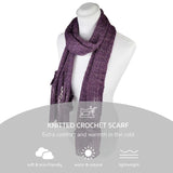 Purple knit crochet scarf with attached shimmering flower on white background.
