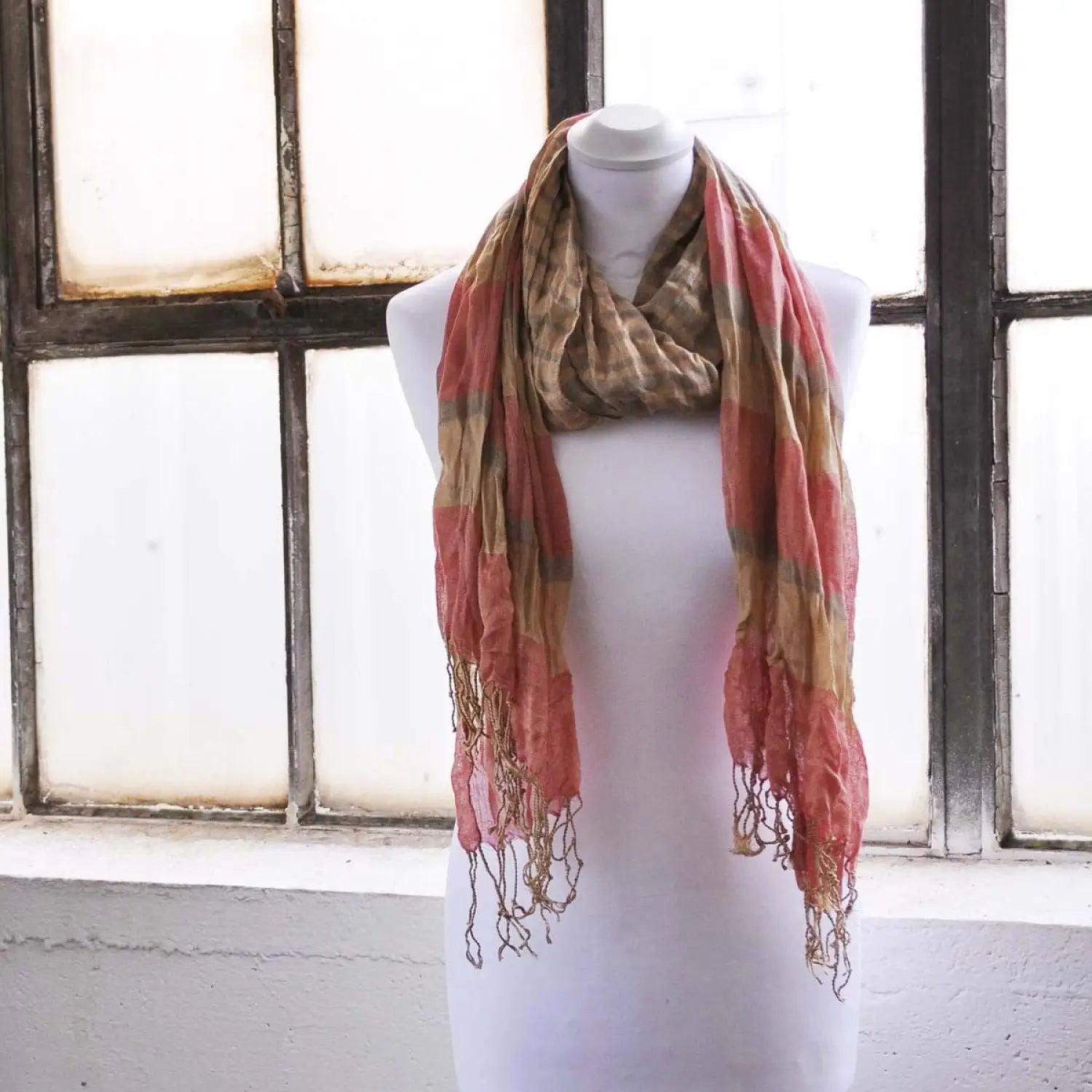 Bold striped crinkled scarf displayed on mannequin in front of window