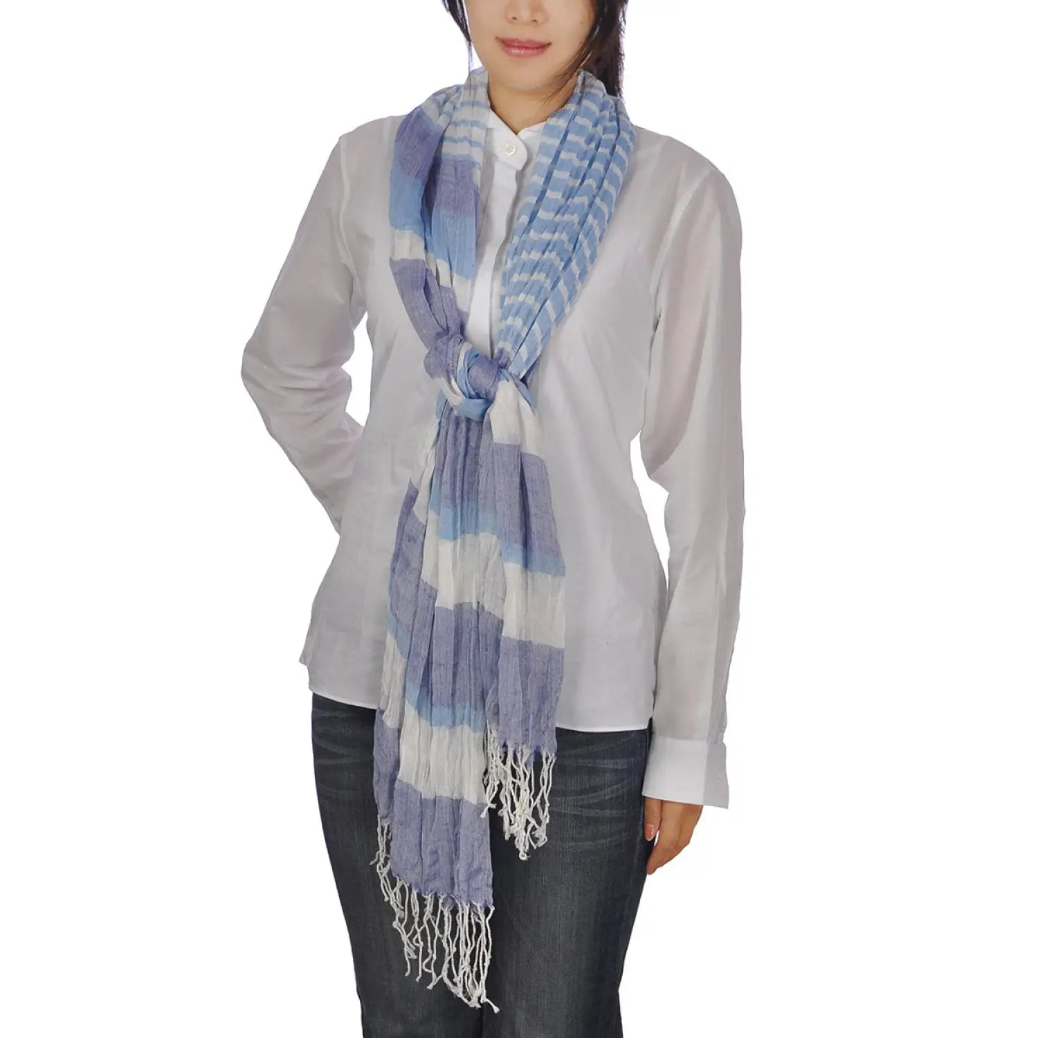 Woman wearing blue and white bold striped crinkled scarf with tassels