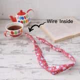 Bunny Ears Retro Rose Print Wire Headband with book and cup on table