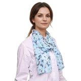 Woman in a white shirt with a light blue butterfly print scarf for versatile styling