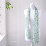 Butterfly print scarf on mannequin in light blue and yellow floral design