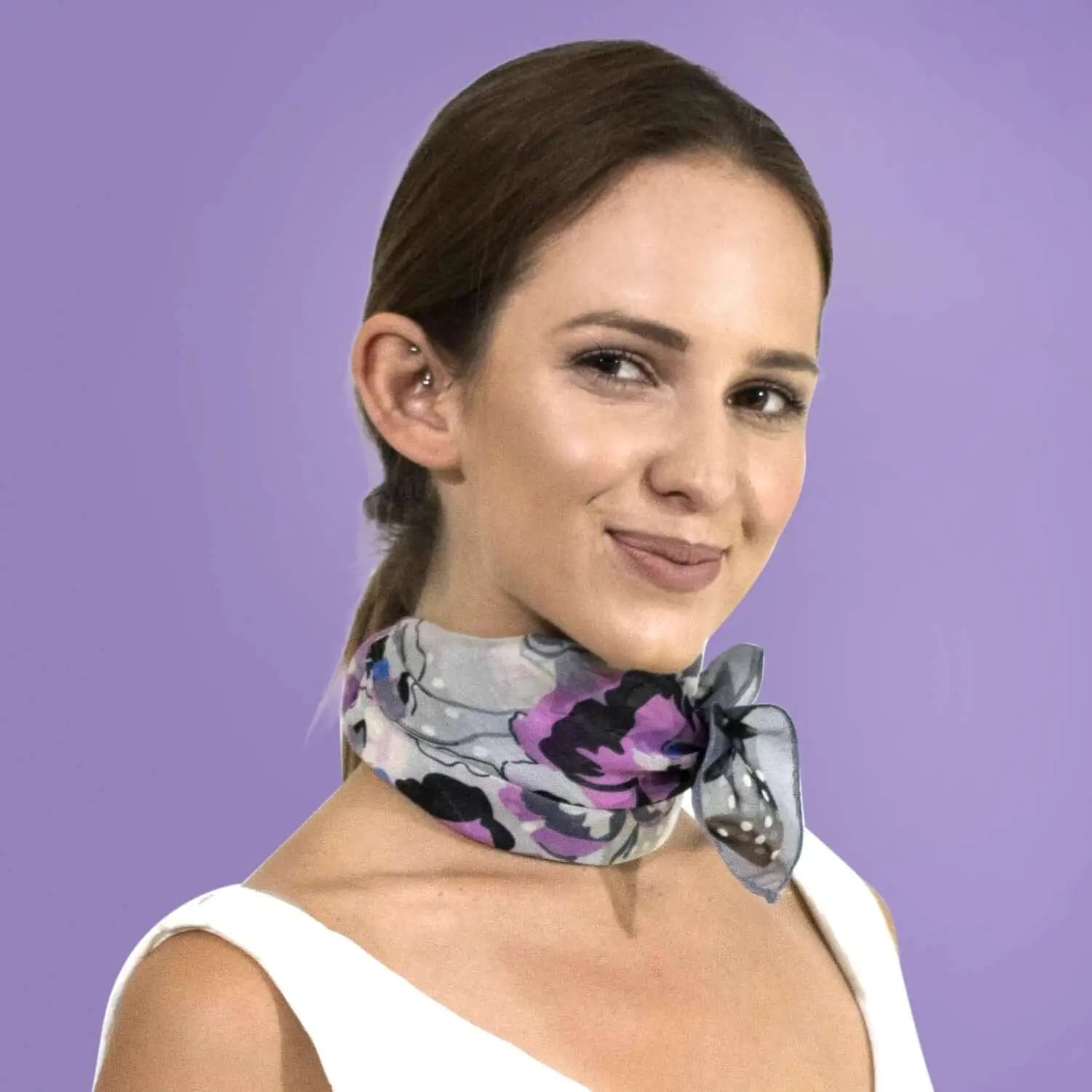 Woman wearing purple and black floral print small square scarf.