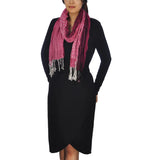 Woman wearing black dress and pink scarf, chic crinkled stripes and leopard print tasselled scarf.