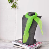 Chiffon square scarf tied to a grey vase