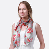 Woman wearing grey and red floral Christmas scarf from the product ’Christmas Scarf Poinsettia Flower Scarves’.