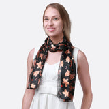 Woman wearing black and orange floral scarf with gingerbread man satin stripe