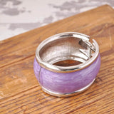Chunky pastel hinged bangle with purple ring on wooden board