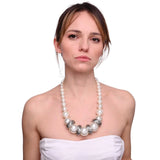 Woman wearing chunky pearl necklace and white dress
