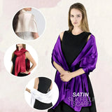 Elegant satin evening scarf in vibrant purple draped over a woman’s shoulders