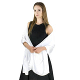 Woman in black sleeveless dress, white satin evening shawl draped over arms