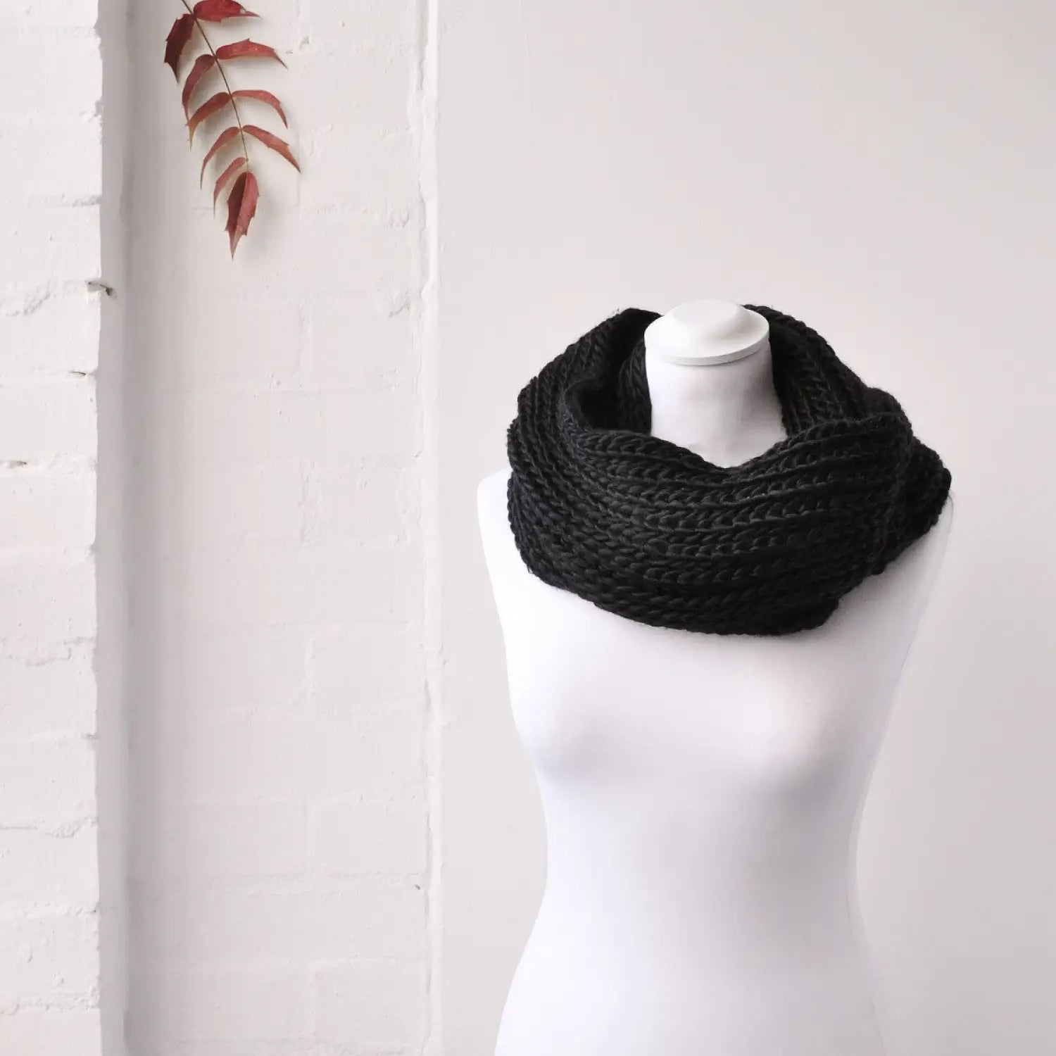 Cozy chunky knit snood on mannequin with black scarf