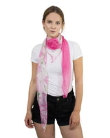 Woman wearing pink floral print chiffon scarf with detachable flower pin.