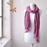 Striking pink scarf on mannequin from Elegant Striped Woven Winter Scarf with playful bobble detail.