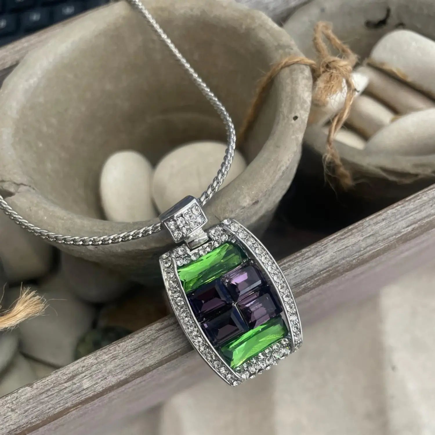 Emerald green and purple stone pendant with diamonds in rectangle pendant necklace.