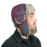 Man wearing faux fur lined thermal winter trapper hat in purple.