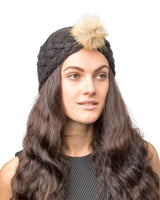 Woman with long brown hair wearing a faux fur pom pom knitted headband