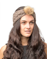 Woman with long brown hair wearing faux fur pom pom knitted headband.
