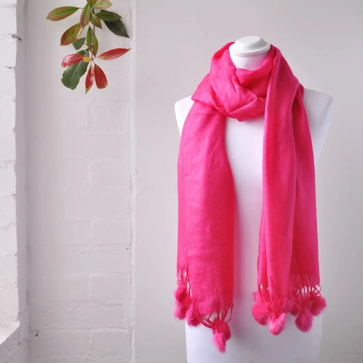 Pink faux fur pom pom pashmina winter scarf on mannequin