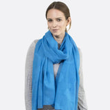 Woman wearing a blue cotton scarf from Floral Leaf Embroidered Collection