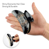 Hand holding black and white rhinestone butterfly hair clamp.