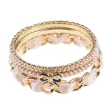 Imitation pearl and peach ribbon stackable gold rings.
