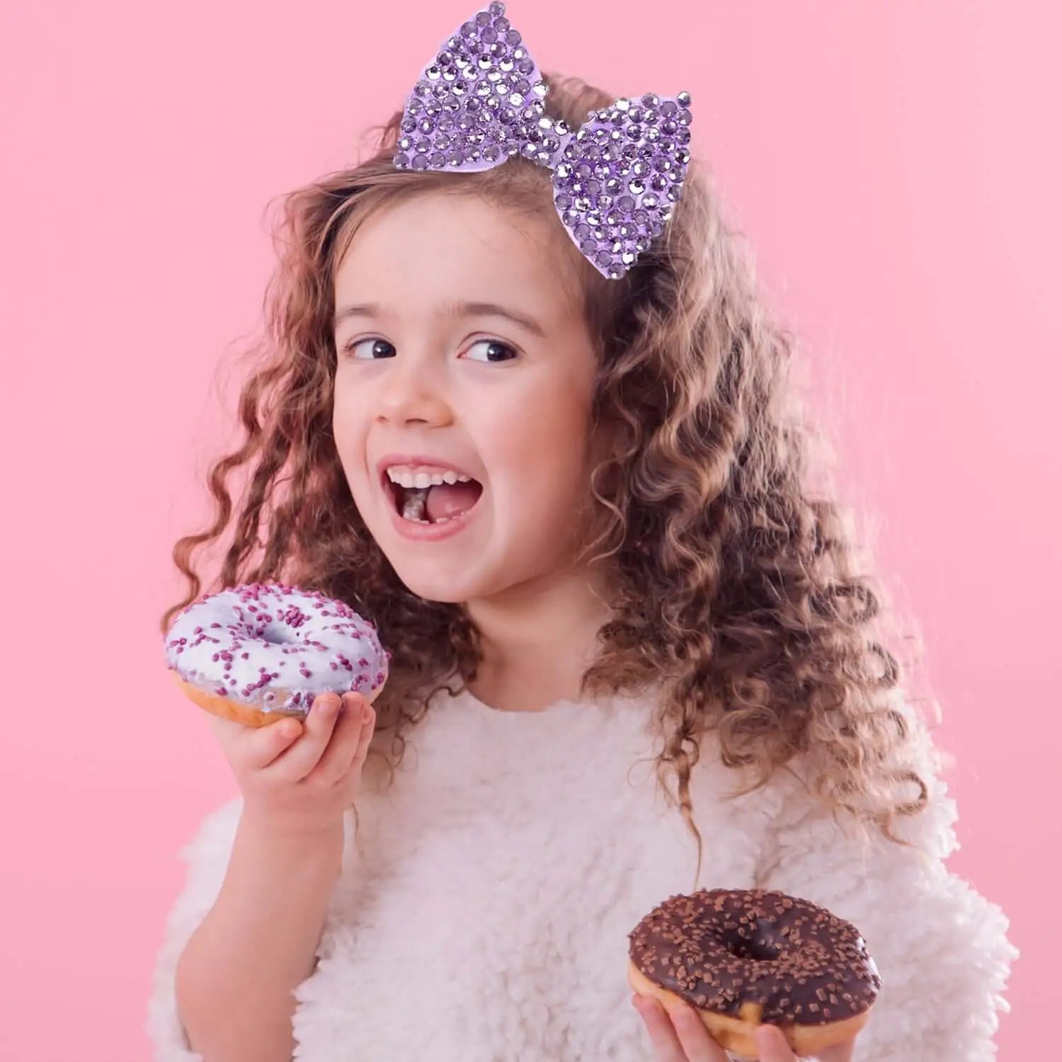 Girl with rhinestone glittery bow hair clips holding a donut and a bow