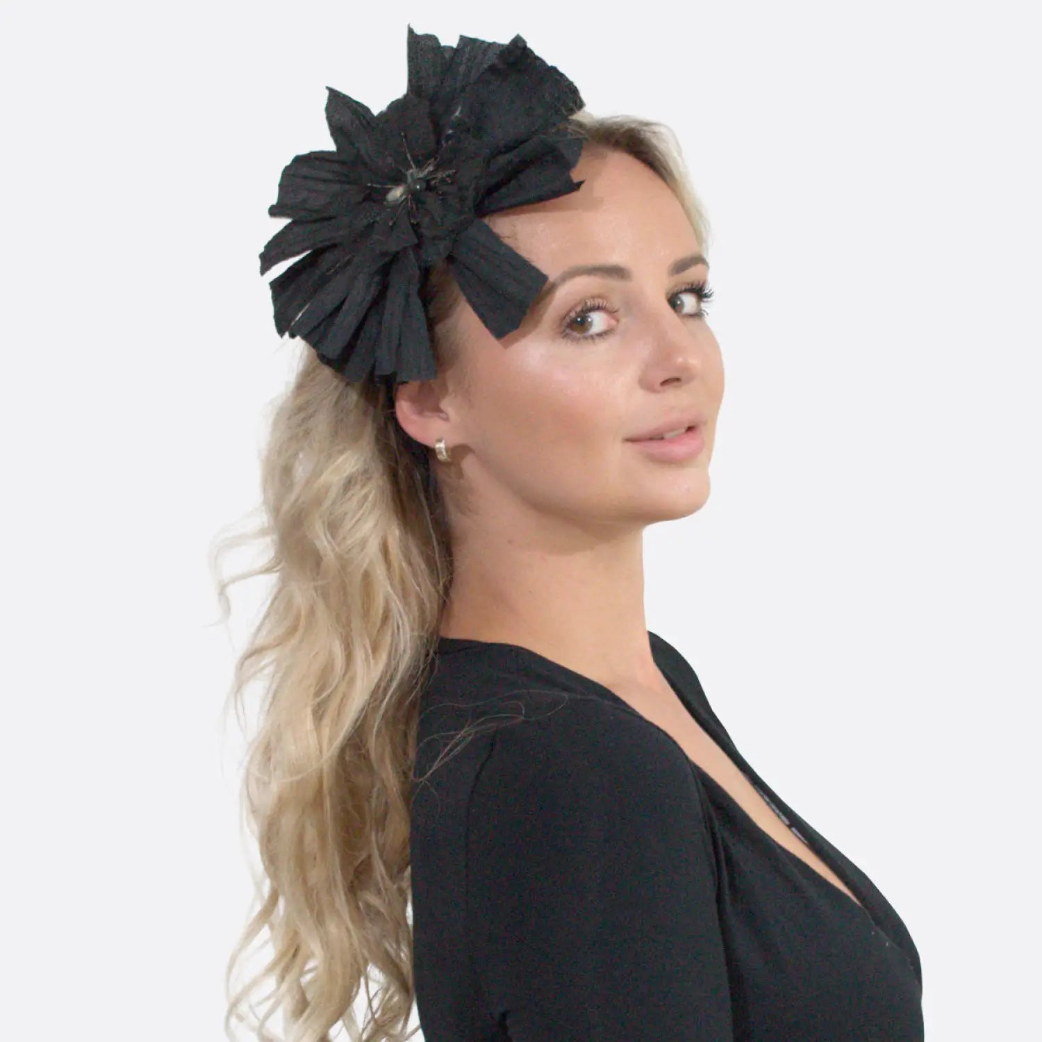 Black headband with large flower and rhinestone applique.