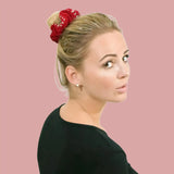 Woman wearing rhinestone velvet hair scrunchies with red bow.