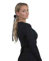 Woman wearing black dress with double satin bow hair comb