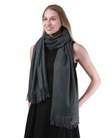 Luxurious cashmere feel oversized scarf in grey worn by a woman