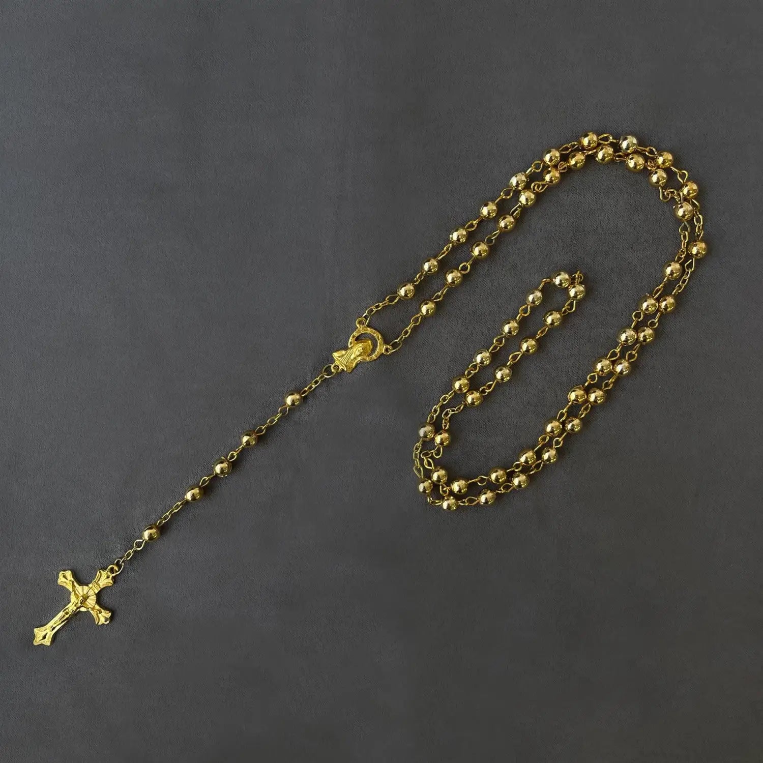 Metallic rosary beads necklace with saints pendant and cross icon.