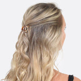 Blonde woman with half updo wearing crystal double arch hair claw.