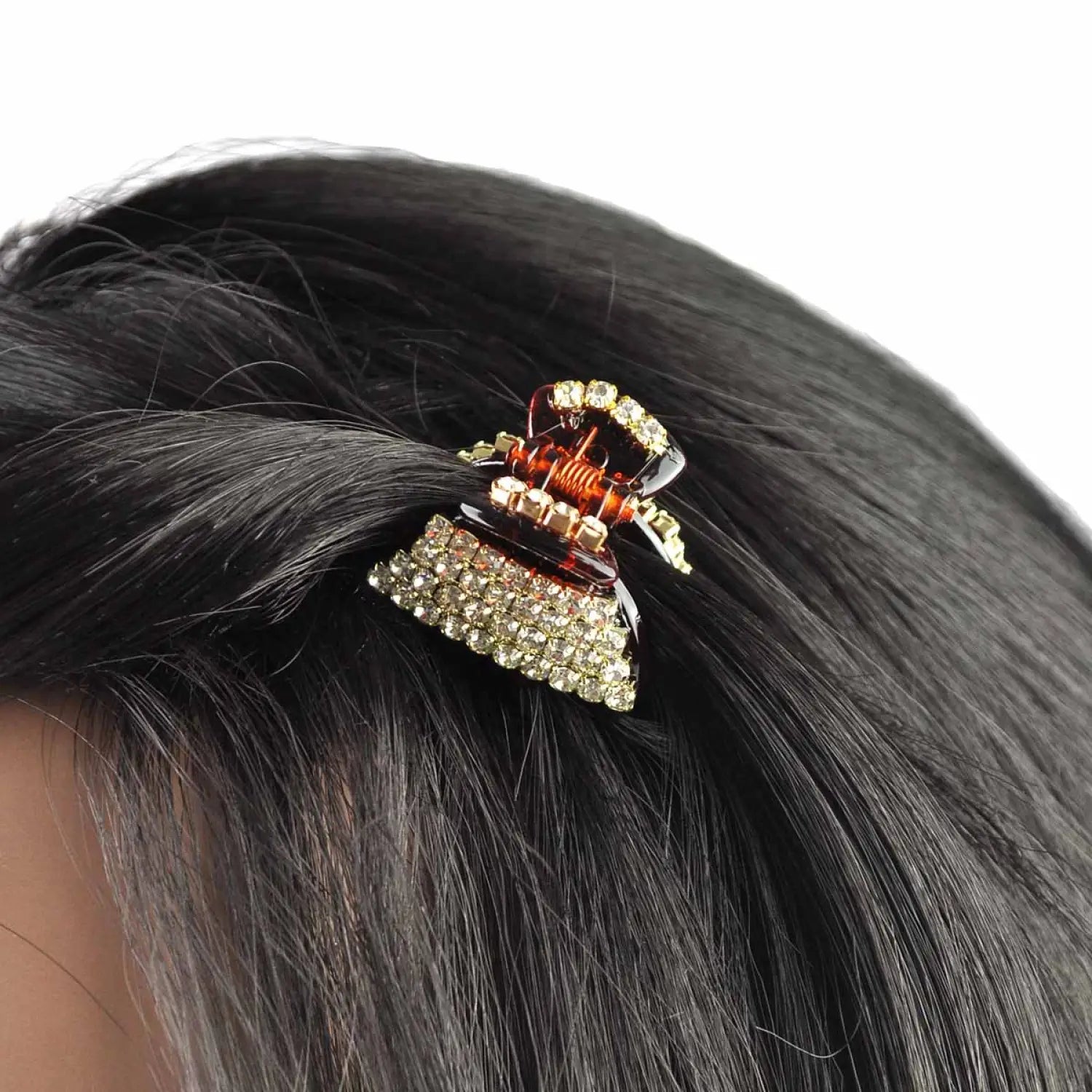 Woman with black hair wearing gold and brown crystal rectangular hair clip.