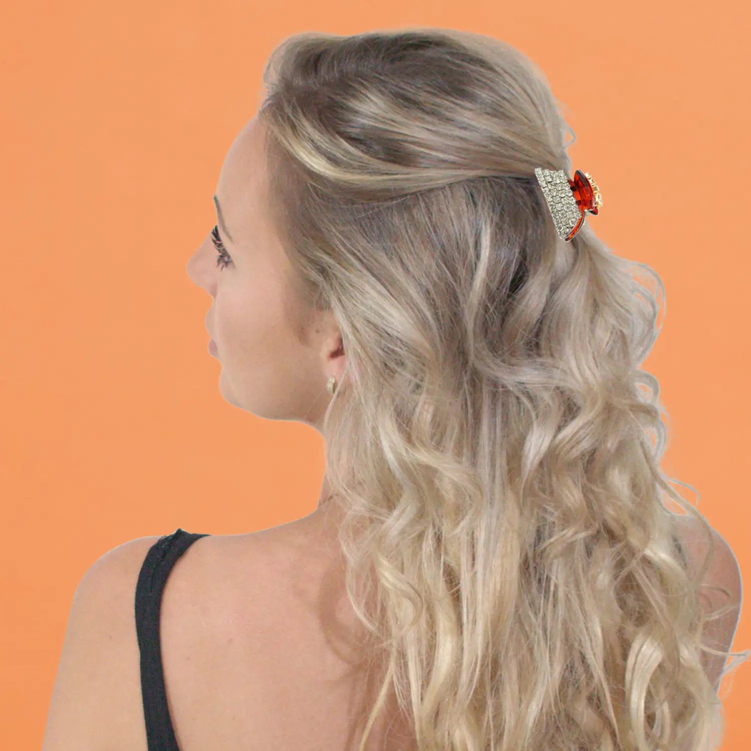 Blonde woman with red flower in hair wearing crystal rectangular hair claw