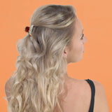 Blonde woman with red flower in hair wearing crystal diagonal line hair claw