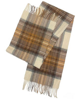 A neatly folded scarf with pale blue and soft beige plaids, accented with brown lines and fringes at the ends, tagged with a label, lying on a flat, light colored surface.