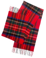 A close-up image of a folded plaid scarf in bright red with black and green checks, prominently featuring fringes at the ends, positioned against a stark white background