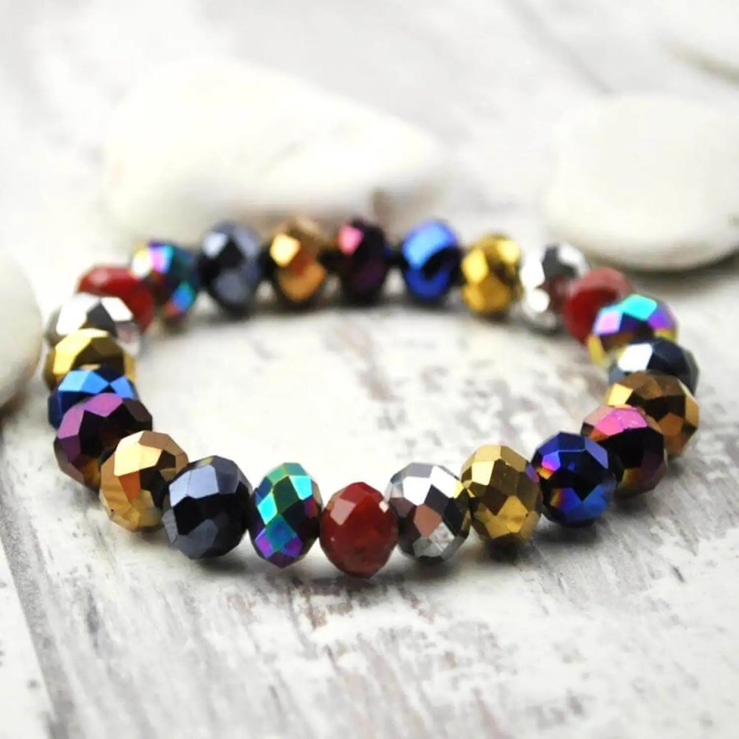 Multi-colour metallic beads bracelet on wooden surface